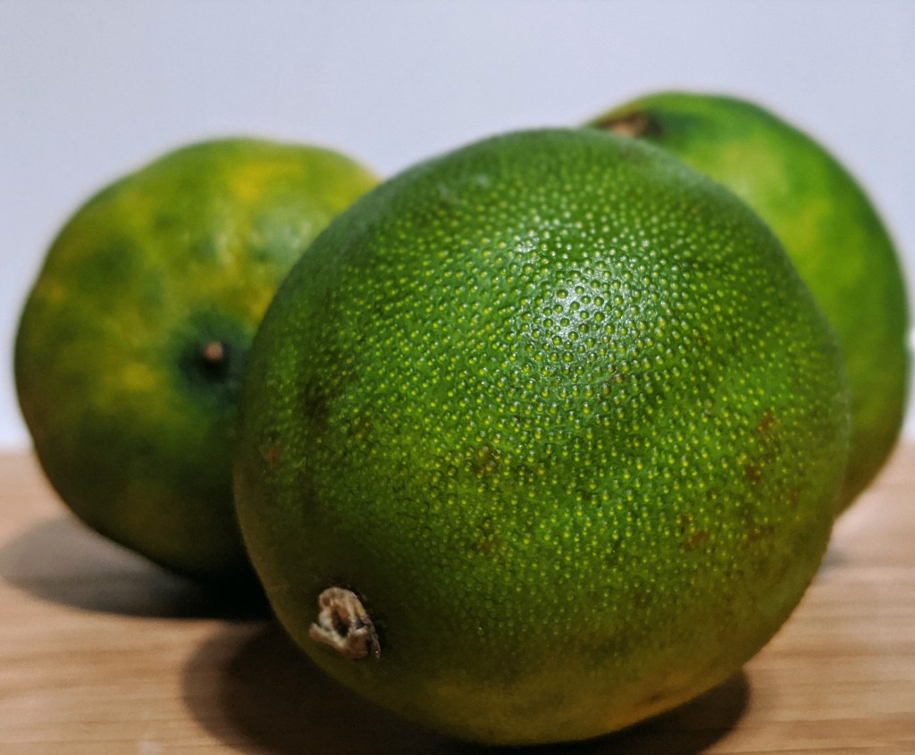 Cluster of bright green limes, round and gathered together. 
