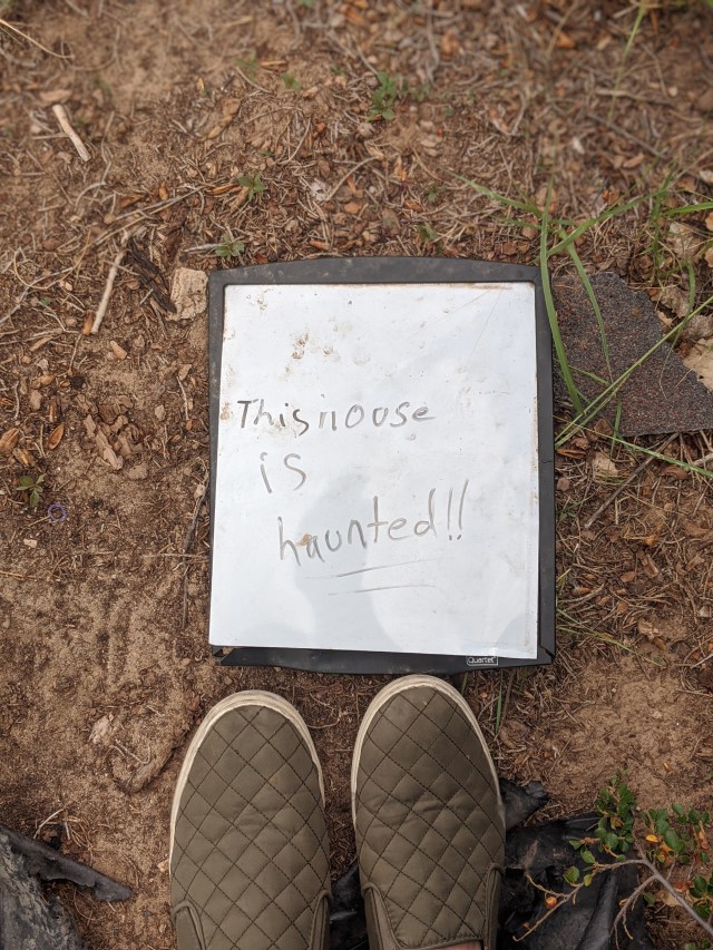 A picture of a sign that says "this house is haunted!!" found during a showing