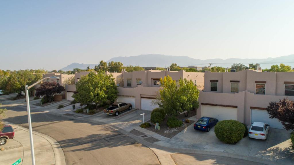 Drone shot of the exterior of the townhome with the Sandia Mountains in the background